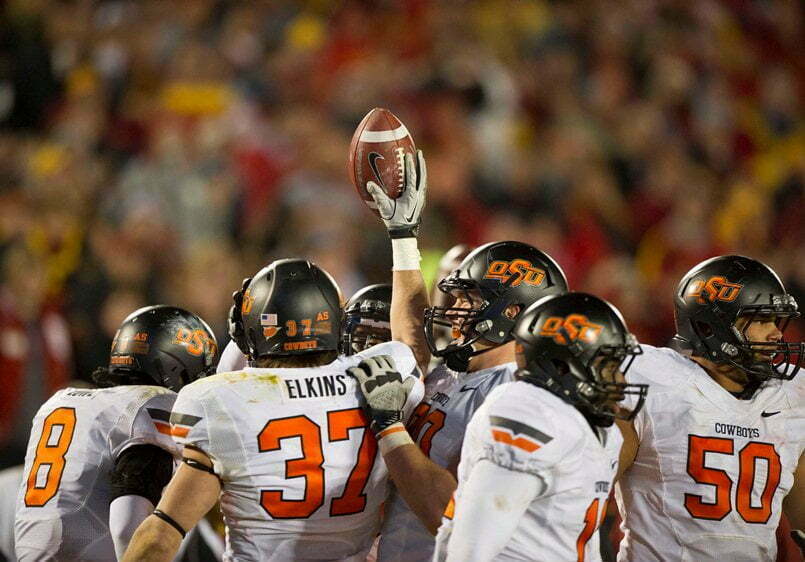 Nov 18, 2011; Ames, IA, USA; Oklahoma State Cowboys linebacker Alex Elkins (37) holds up the football while surrounded by teammates during the second half of a game against the Iowa State Cyclones at Jack Trice Stadium. Iowa State Cyclones defeated the Oklahoma State Cowboys 37-31. Mandatory Credit: Beth Hall-US PRESSWIRE