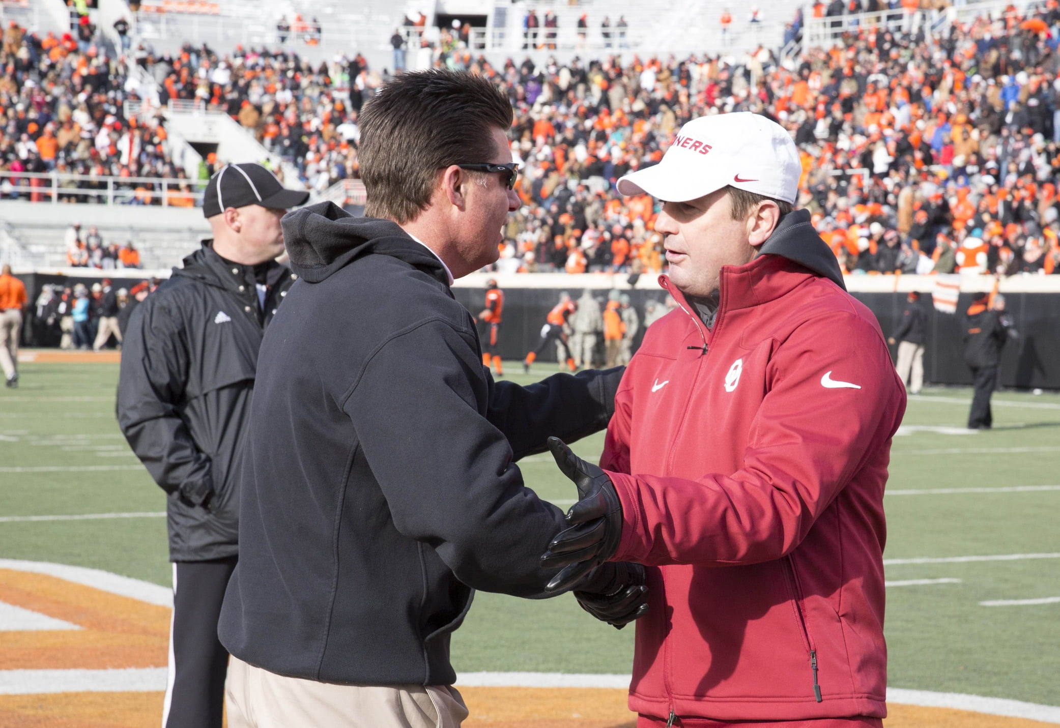 Mike Gundy and Bob Stoops share a moment in 2013. (USATSI)